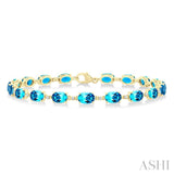 6X4 MM Oval Cut Blue Topaz and 1/6 Ctw Round Cut Diamond Semi-Precious Tennis Bracelet in 10K Yellow Gold